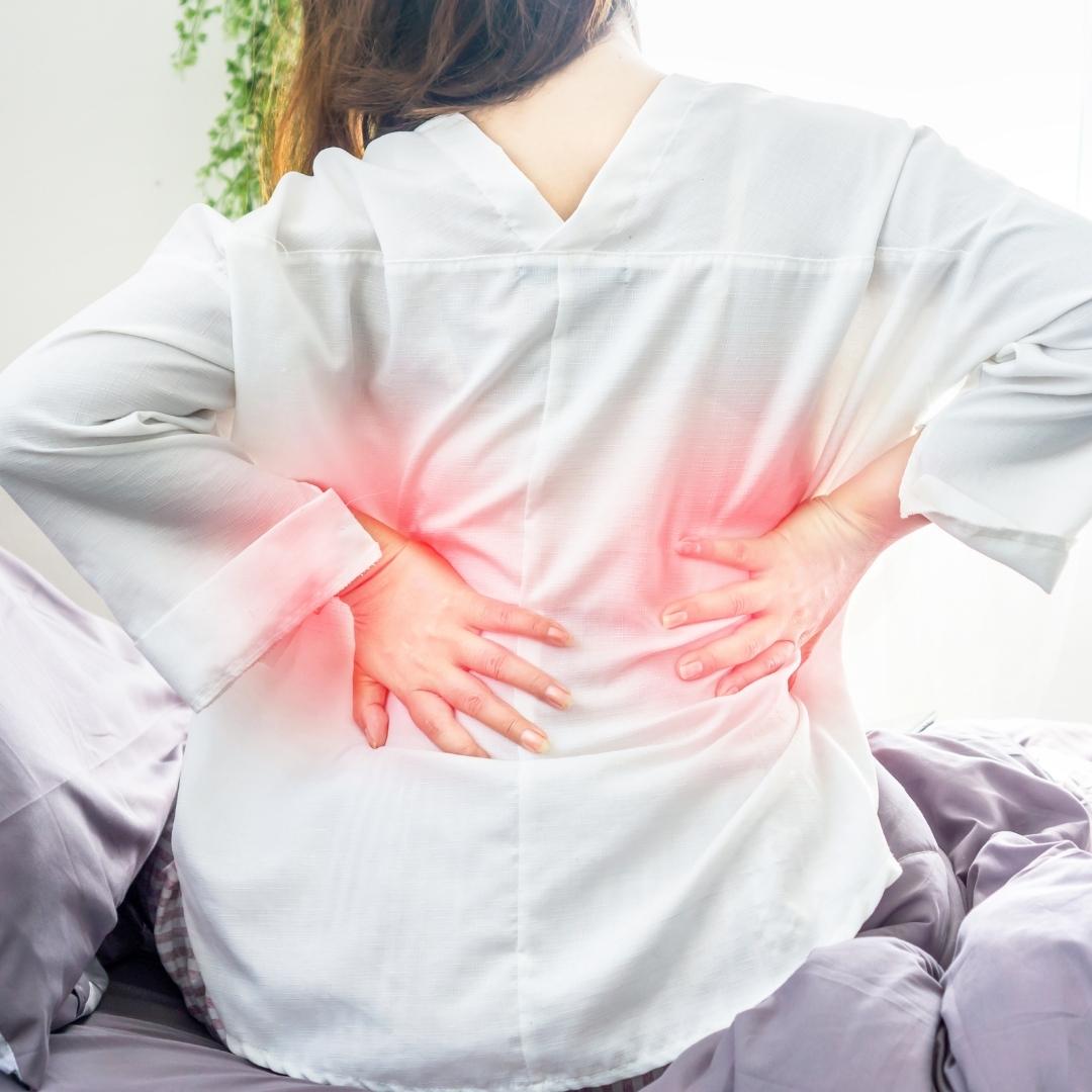 אישה סובלת מכאבי גב תחתון, גב תפוס ולחץ שנובע מדלקת בגב התחתון